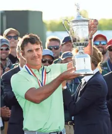  ?? ROB SCHUMACHER, USA TODAY SPORTS ?? Brooks Koepka hoists the trophy after he tied the scoring mark in winning the U.S. Open at Erin Hills.