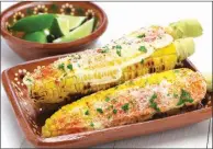  ?? TRIBUNE CONTENT AGENCY ?? Grilled Mexican street corn is coated with a thin layer of garlic mayonnaise and rolled in a salty, dry cheese.