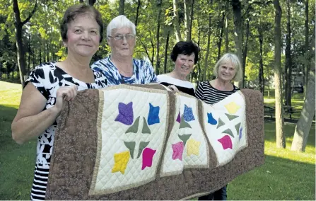  ?? JESSICA NYZNIK/ EXAMINER ?? From left, Darlene Sullivan, Anna Dyer, Barbara Vollering and Debbie Youngman, members of the Catholic Women's League of St. Joseph Parish Hall, display the Tulips of Douro quilt outside the parish hall Wednesday. The quilt will be raffled off at the...