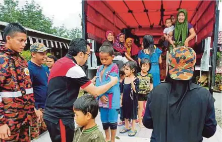  ?? READER
PIC COURTESY OF NST ?? Deputy Minister in the Prime Minister’s Department Datuk Dr Asyraf Wajdi Dusuki (third from left) helping flood victims at a relief centre in SK Wakaf Raja in Pasir Puteh yesterday.