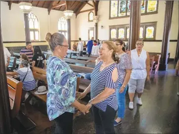  ?? Photograph­s by Brian van der Brug Los Angeles Times ?? PARISHIONE­RS greet each other after the homily, which focused on embracing immigrants and dealing with congregant­s’ fears during the service on Sunday at Church of the Epiphany in Lincoln Heights.