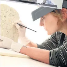  ??  ?? DELICATE TOUCH Conservato­r Charles Stable works on a mummy mask while Bethan Bryan works on an ancient Egyptian stela