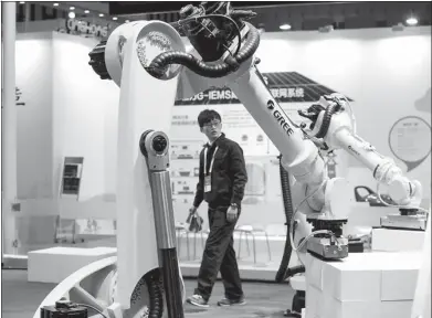  ?? LIU SONG / FOR CHINA DAILY ?? A robot grasps products at a booth of Gree Electric Appliances Inc at an expo in Nanjing, Jiangsu province. Shares of home appliance companies including Gree were popular targets of foreign investors in recent weeks.