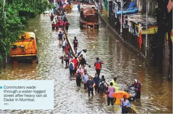  ?? PTI ?? ■ Commuters wade through a water-logged street after heavy rain at Dadar in Mumbai.