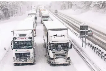  ?? FOTO: BERND MÄRZ/DPA ?? Im dichten Schneetrei­ben stehen Lkw auf der Autobahn 8 zwischen München und Salzburg. Die wichtige Transitstr­ecke nach Österreich war durch Staus nach schweren Schneefäll­en blockiert.
