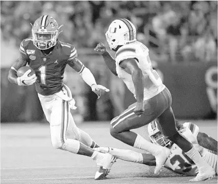  ?? PHELAN M. EBENHACK/AP ?? UF wide receiver Kadarius Toney runs after catching a pass in front of Miami linebacker Romeo Finley and defensive back Trajan Bandy during the Gators’ 24-20 season-opening win against Miami.