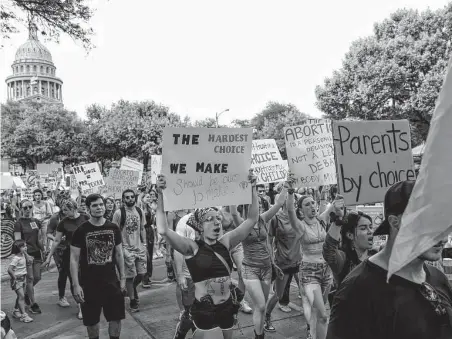  ?? Sam Owens / Staff photograph­er ?? Abortion rights activists march along Congress Street near the Capitol in Austin on Tuesday. The protest was in reaction to a leaked draft opinion from the U.S. Supreme Court that shows that the justices plan to overturn Roe v. Wade.