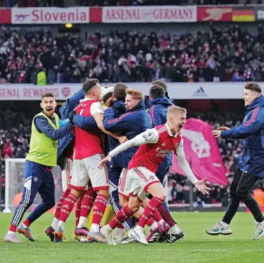  ?? | EPA ?? REISS Nelson is mobbed by teammates after scoring Arsenal’s winning goal in their dramatic victory over Bournemout­h on Saturday.