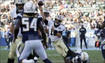  ?? MARCIO JOSE SANCHEZ — THE ASSOCIATED PRESS ?? Saints QB Tom Savage of Cardinal O’Hara throws a pass as he is hauled down by Chargers defensive tackle Corey Liuget (94) during the first half of a game Saturday in Carson, Calif.