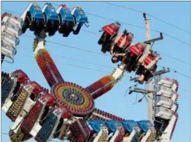  ?? JONATHAN TRESSLER — THE NEWS-HERALD ?? A pair of brave souls go upside-down on the “Spin Out” during the first few hours of the 58th annual Kirtland Kiwanis Strawberry Festival June 15.