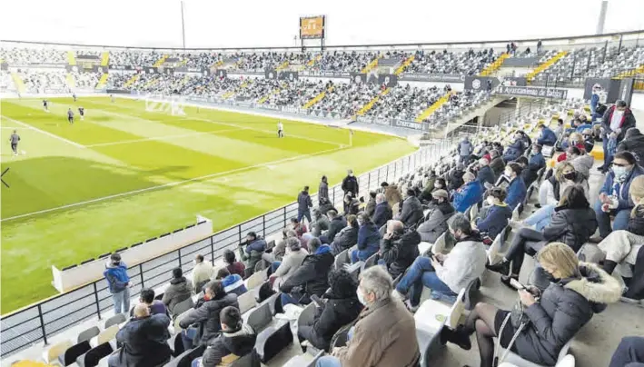  ??  ?? Aficionado­s siguen el partido entre Badajoz y Talavera en el Nuevo Vivero.