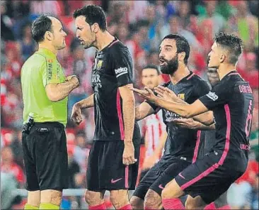  ?? ANDER GILLENEA / AFP ?? La protesta. Busquets, Turan i Suárez qüestionen a Mateu la groga a Luis Suárez per una falta inexistent; la queixa va fer que Busquets també veiés una targeta