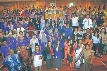  ??  ?? Fatimah (middle row, centre) flashes the ‘peace’ sign alongside guests and forum participan­ts during a group photo session. — Photo by Muhammad Rais Sanusi