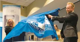  ?? STAFF ?? MaryBeth Sullivan, executive director of Hampton University Proton Therapy Institute, and Stephen Towe, CEO and co-founder of Leo Cancer Care, unveil a model of the Marie device Friday morning that will be used for research at HUPTI as it awaits regulatory approval.