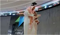  ?? — AP ?? Saudi men walk at the Tadawul Saudi Stock Exchange in Riyadh.