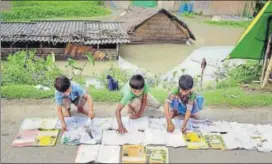  ?? PTI ?? Students lay their books on the road to dry in floodaffec­ted Morigaon, Assam, on Wednesday.