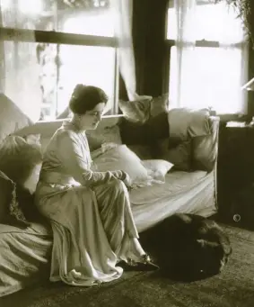  ??  ?? Lucy sits with her chow Mahmud in the sun room of her Long Island, New York, beach house in 1916.