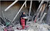  ?? PTI ?? Afghan girl salvages belongings from her destroyed house after an earthquake in Gayan district in Paktika province, Afghanista­n