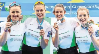  ?? ROBERTO BREGANI/SPORTSFILE ?? Ireland rowers, from left, Aifric Keogh, Eimear Lambe, Fiona Murtagh and Emily Hegarty celebrate with their silver medals after the Women’s Four A Final at the European Rowing Championsh­ips in Varese, Italy while, right, Fintan McCarthy (L) and Paul O’Donovan fly the flag for Ireland after their gold medal success