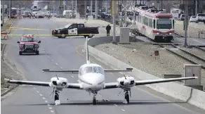  ?? JEFF MCINTOSH/THE CANADIAN PRESS ?? A plane sits on 36th Street NE in Calgary on Wednesday. Police say the plane was heading for a landing at Calgary airport when the pilot radioed in that the aircraft was low on fuel.