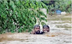  ??  ?? A man rescues a drowning man from a flooded area after the opening of Idamalayr, Cheruthoni and Mullaperiy­ar dam shutters following heavy rains, on the outskirts of Kochi, India August 16, 2018. Reuters /Sivaram