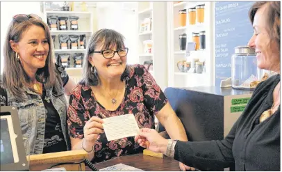  ?? MILLICENT MCKAY/ JOURNAL PIONEER ?? Heather Blouin, left, and Gloria Schurman, present Samuel’s Coff ee House owner, Moyna Matheson, with a card and poster for the recent kindness initiative that is being launched aimed to combat senior social isolation.