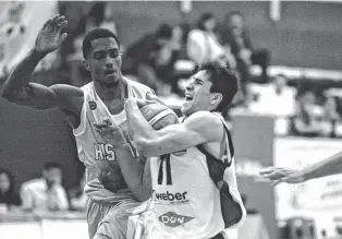  ??  ?? Con toda su potencia, Santiago Vaulet atenaza el balón mientras lo sigue Larry O'Bannon (Hispano). Bahía Basket aún no pudo ganar en la Liga. Esta noche tendrá otra chance.