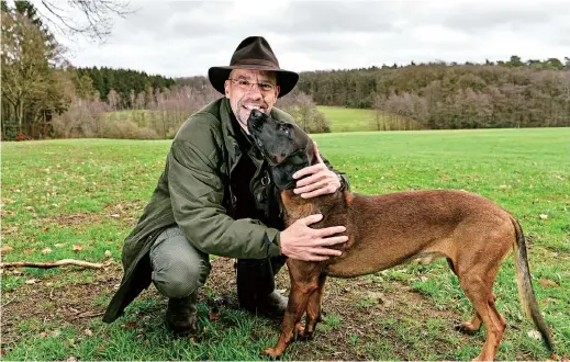  ??  ?? Dirk Gratzel poses for a photo with his dog at his hunting ground in Stollberg, Germany. — IC