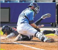  ?? Curtis Compton The Associated Press ?? Atlanta’s Justin Dean beats the tag of Tampa Bay catcher Kevan Smith in the fourth inning of the Rays’ 9-7 win in Port Charlotte, Fla.