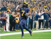  ?? ?? Michigan Wolverines running back Donovan Edwards reacts after running for a 46-yard touchdown during the national championsh­ip College Football Playoff game Monday in Houston.