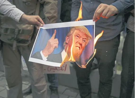  ??  ?? En Teherán, manifestan­tes queman una imagen de Trump luego de que Estados Unidos dejara el acuerdo nuclear