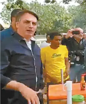  ??  ?? Bolsonaro foi a pontos do comércio no bairro Sudoeste, em Brasília, e cumpriment­ou populares