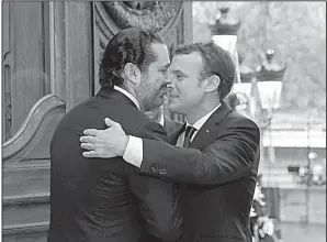  ?? AP/PHILIPPE WOJAZER ?? French President Emmanuel Macron (right) greets Lebanese Prime Minister Saad Hariri before a meeting Friday in Paris.