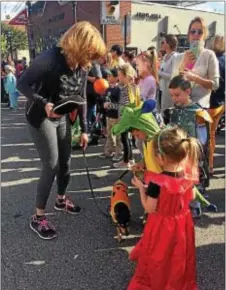  ?? KATHLEEN CAREY – DIGITAL FIRST MEDIA ?? A “pumpkin” from Media Veterinary Hospital meets with children at the Halloween parade.