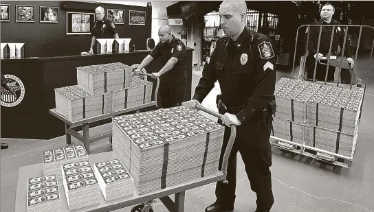  ??  ?? ■ 48-HOUR DISTRIBUTI­ON: These seldom seen uncut sheets of new $2 bills are being moved from the private vaults of the Lincoln Treasury for immediate distributi­on to Atlanta area residents. Residents who beat the 48-hour order deadline to get the vault...