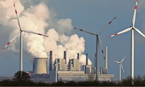  ?? Foto: Oliver Berg, dpa ?? Wenn Windräder auf ein rauchendes Braunkohle­kraftwerk treffen, dann entstehen immerhin reizvolle Fotomotive. Doch in der Großen Koalition sorgt das Thema Klimaschut­z derzeit eher für Krach.