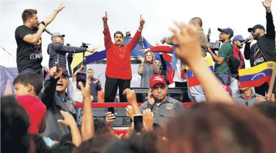  ??  ?? ► Nicolás Maduro saluda a sus simpatizan­tes durante un acto de campaña en Caracas, el viernes pasado.