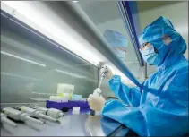  ?? TANG DEHONG / FOR CHINA DAILY ?? A technician checks export-bound COVID-19 testing kits at a biotech firm in Taizhou, Jiangsu province.