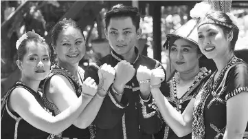  ??  ?? Dancers at Monsopiad Heritage Village displaying their wristbands in support of the #AnakAnakMa­laysia campaign.