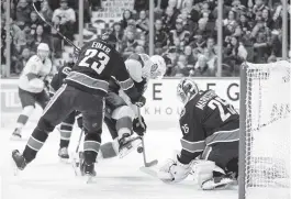  ?? DARRYL DYCK AP ?? The Canucks’ Alexander Edler checks the Panthers’ Aleksander Barkov as Barkov attempts a shot against Vancouver goalie Jacob Markstrom on Sunday night.