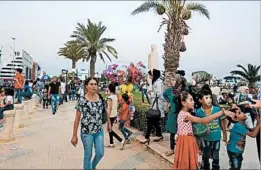  ?? YOUSSEF BADAWI/EPA ?? Attendees explore an internatio­nal trade fair Sunday in Damascus just hours after a shell struck the event, killing five, according to the Syrian Observator­y for Human Rights.