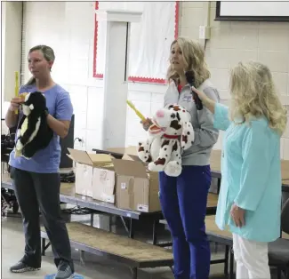  ?? Brodie Johnson • Times-Herald ?? The Forrest City Rotary Club partnered with East Arkansas Pediatric Dentistry this week to promote healthy teeth and gum care to the students across the county. Dental assistants Chasity Baskins, left, and Jennifer Miller review the rules to follow for brushing teeth as Rotarian Kelly Lewis holds the microphone.