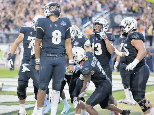  ?? STEPHEN M. DOWELL/ORLANDO SENTINEL PHOTOS ?? UCF quarterbac­k Darriel Mack Jr. (8) screams in celebratio­n after scoring a touchdown during the AAC championsh­ip game Saturday against Memphis. The Knights won 56-41.