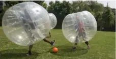  ??  ?? Bubble players flail in the ball’s general direction on the soccer field.