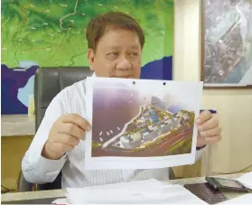  ?? SUNSTAR FOTO / ALAN TANGCAWAN ?? KAWIT DEVELOPMEN­T. Mayor Tomas Osmeña shows to reporters a photo of a developmen­t plan for Kawit Island. .