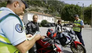  ??  ?? Johan et Audrey Morand, motards savoyards, contrôlés hier à la Roquette-sur-Var. En règle, et parfaiteme­nt équipés. « Même en août par plus de °C, c’est indispensa­ble. » (Photos Frantz Bouton)