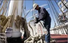  ?? MARK LENNIHAN — THE ASSOCIATED PRESS ?? In this photo, Vidal Lopez coils rope on the deck of the Wavertree in the Staten Island borough of New York. The historic three-mast sailing ship is returning to New York City’s seaport district as the centerpiec­e of a museum that is making a comeback.