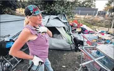  ?? PHOTOGRAPH­S BY MARIA ALEJANDRA CARDONA Los Angeles Times ?? SHARON, who gave only her first name, begins taking down the camp she has lived in for the last 16 years along the Santa Ana River. Many expect some of those who leave the camps to end up in other public spaces.