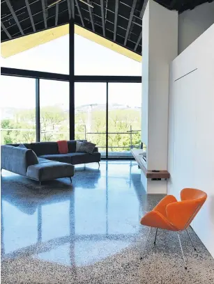  ??  ?? The polished concrete floor has stones gathered from local beaches. A spacesavin­g swivel door is hidden within the wall at right; the ceiling is still to be completed.