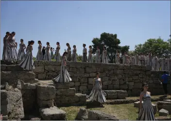  ?? THANASSIS STAVRAKIS — THE ASSOCIATED PRESS ?? Performers, who will take part in the flame-lighting ceremony today for the Paris Olympics, leave after a rehearsal at the Ancient Olympia site in Greece on Sunday. The site is the ancient birthplace of the Olympics.